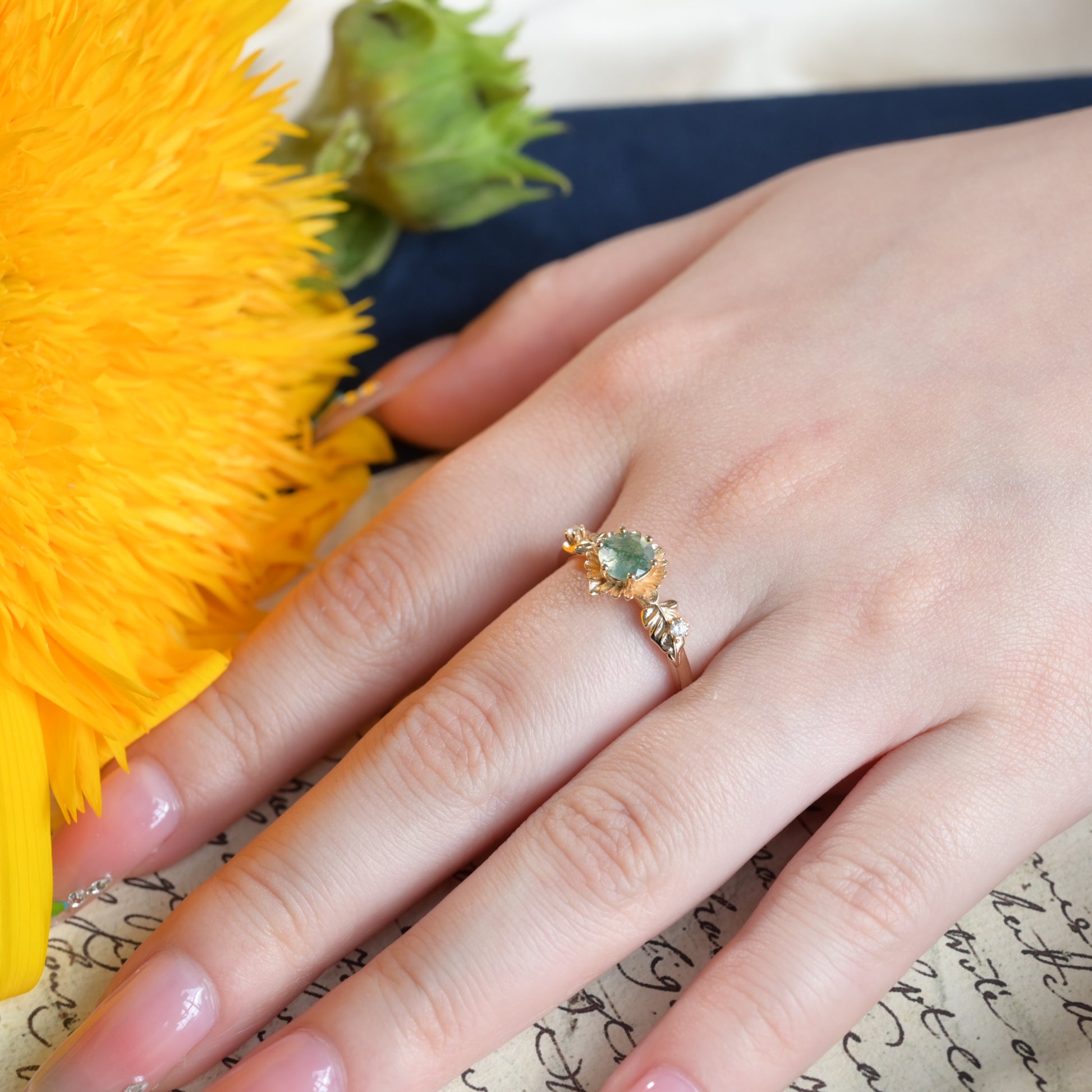 Anillo redondo de ágata musgosa con flor de girasol tallada