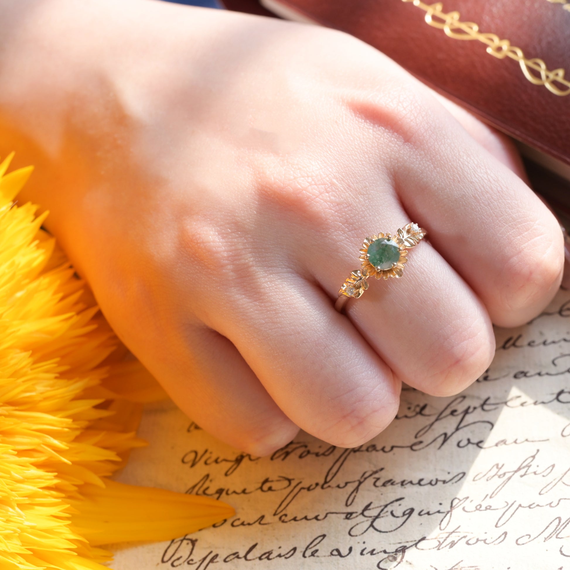 Anillo redondo de ágata musgosa con flor de girasol tallada